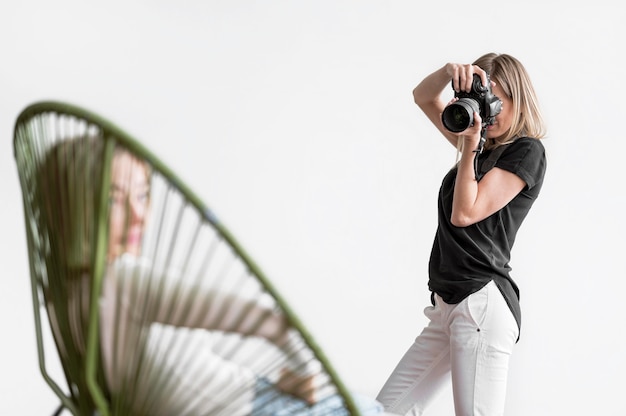 Mulher sentada em uma cadeira e sendo fotografada