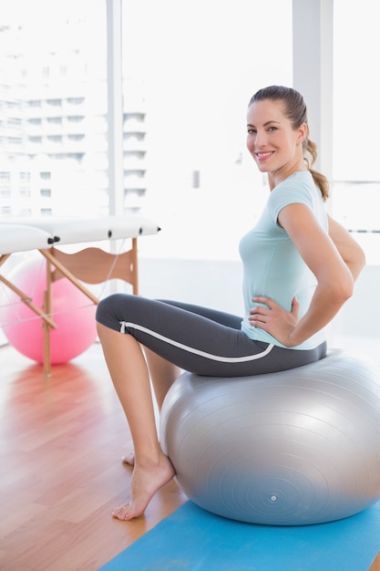 Mulher sentada na bola de exercício