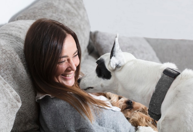 Mulher sentada na poltrona brincando com o cachorro,