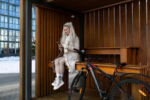 Mulher sentada no banco ao lado da bicicleta