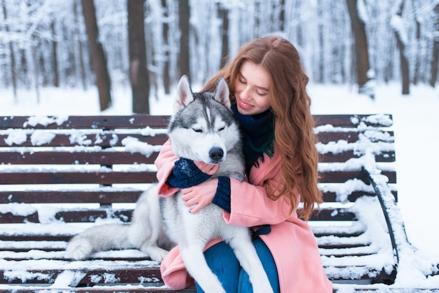 Mulher sentada no banco com husky siberiano