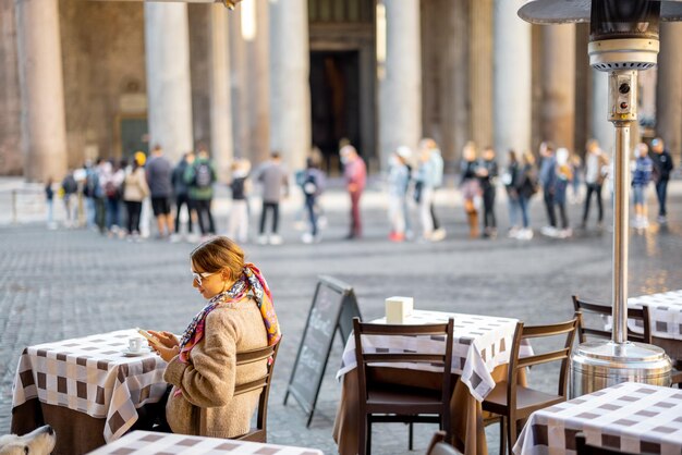 Foto mulher sentada no café ao ar livre perto do templo panthenon em roma