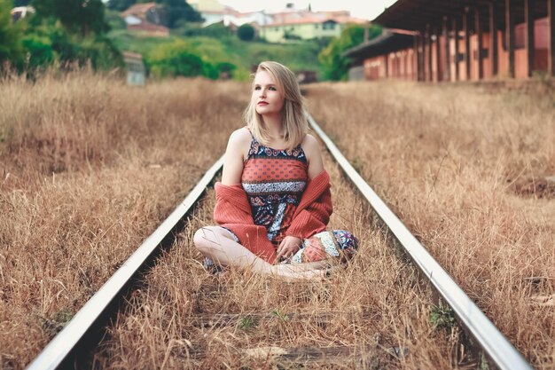 Foto mulher sentada no caminho-de-ferro