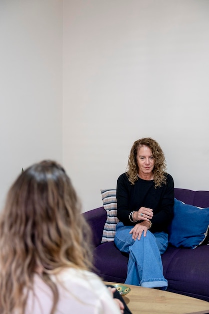 Foto mulher sentada no sofá enquanto tem uma sessão de terapia no escritório do psicólogo