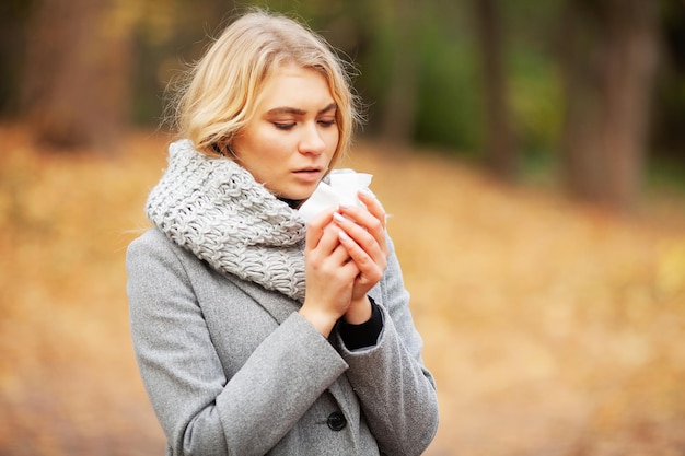 Mulher sentindo frio no parque de outono