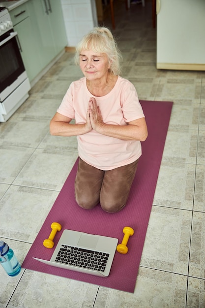 Mulher serena fazendo exercício de meditação em casa