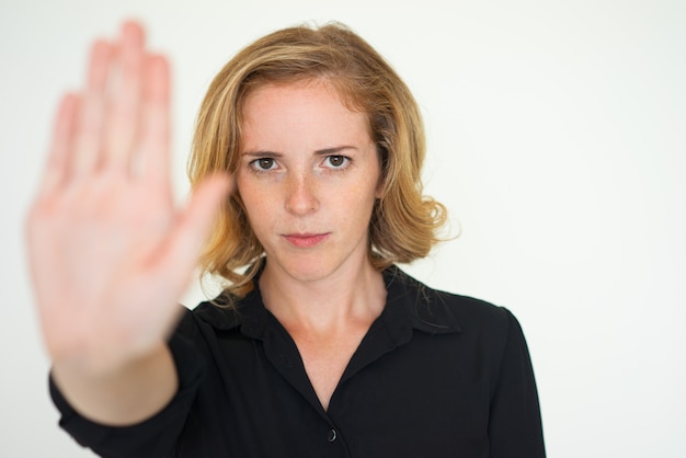 Foto mulher séria séria, mostrando o gesto de parada
