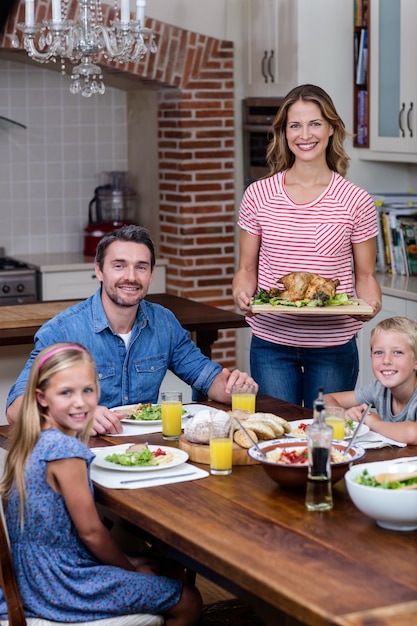 Foto mulher servindo comida para sua família na cozinha