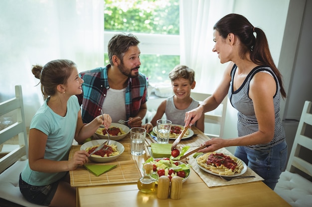 Foto mulher servindo refeição para sua família