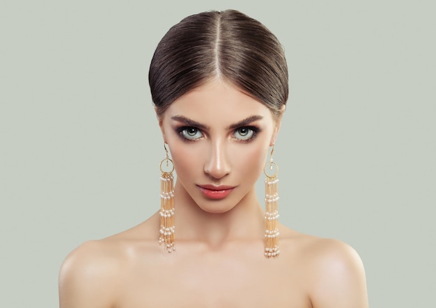 Mulher sexy com corte de cabelo reto e saudável e brincos de joias de ouro com pérolas lindo retrato feminino