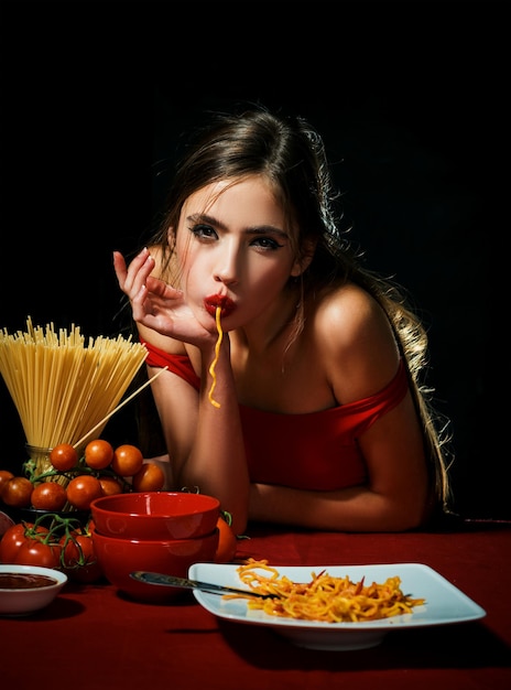 Mulher sexy com macarrão espaguete em quarto escuro