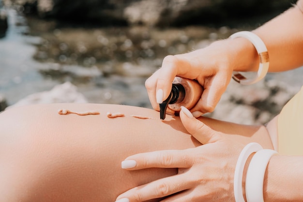 Mulher sexy de loção bronzeadora em biquíni aplica creme de proteção solar em suas pernas bronzeadas suaves cuidados com a pele