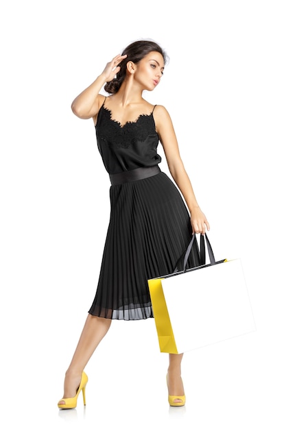 mulher sexy de vestido preto com sacolas de compras, isoladas no fundo branco.