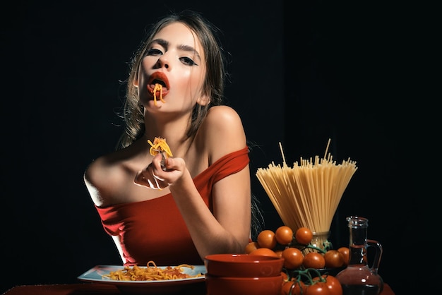 Foto mulher sexy em estilo italiano comendo espaguete com as mãos mulher sexy da cozinha segura prato com espaguete