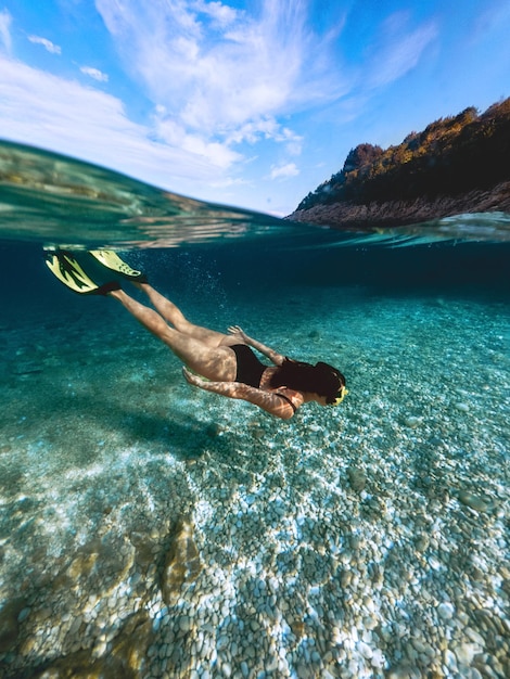 Foto mulher sexy nadando debaixo d'água em máscara de mergulho com nadadeiras nas férias de verão