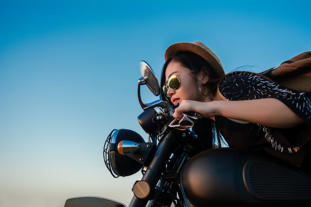 Mulher &quot;sexy&quot; nova em uma motocicleta na natureza no por do sol. Conceito de viagens.