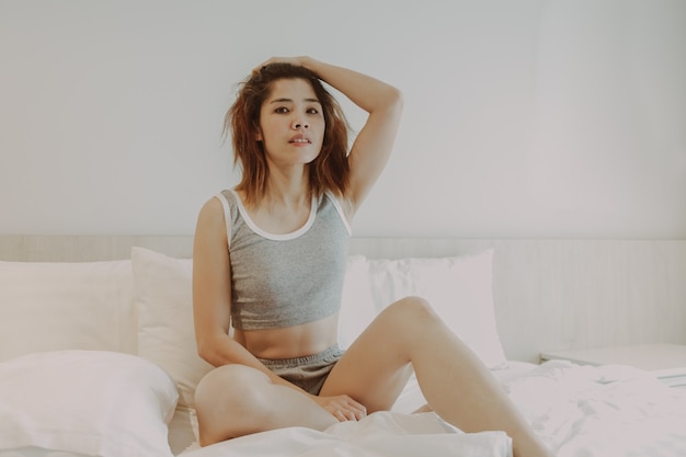 Mulher sexy relaxando na cama sozinha no quarto