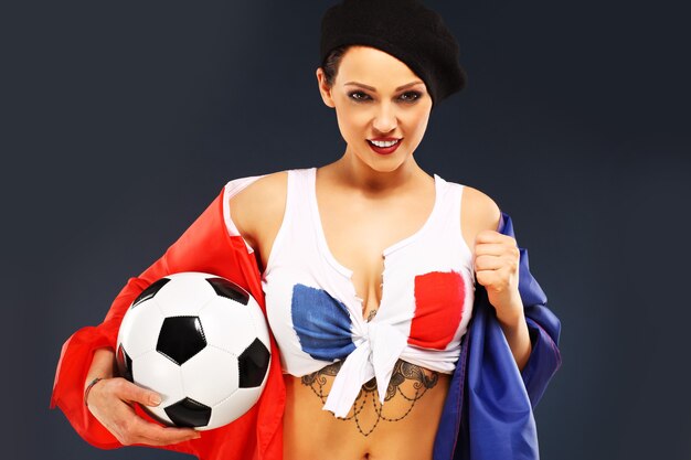 Foto mulher sexy usando a bandeira da frança e segurando uma bola de futebol