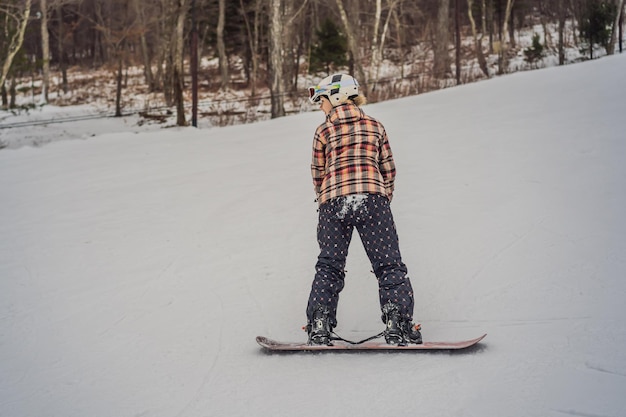 Mulher snowboarder em um dia ensolarado de inverno em uma estação de esqui