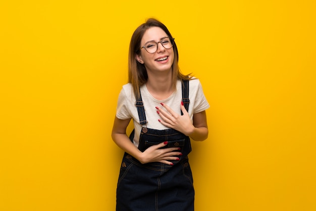 Mulher, sobre, parede amarela, sorrindo, muito