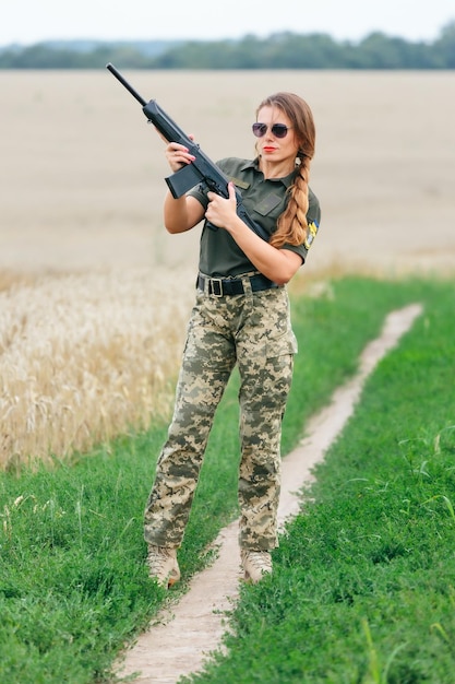 Mulher soldado em uniforme militar Uma garota em uniforme militar com uma arma