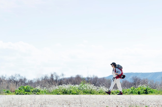 Mulher solitária caminhando com uma mochila praticando caminhada