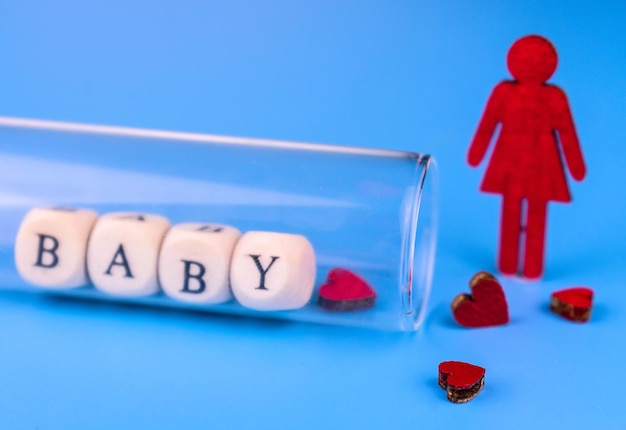 Mulher solitária e tubo de ensaio de laboratório com letras para bebê Conceito de inseminação artificial