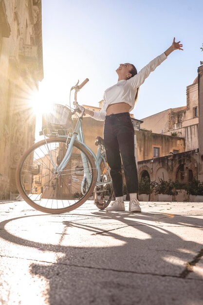 mulher sorridente andando de bicicleta na estrada da cidade na praça barroca na itália imagem do conceito de turista