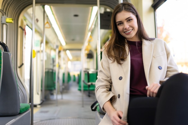 Mulher sorridente andando no bonde da cidade