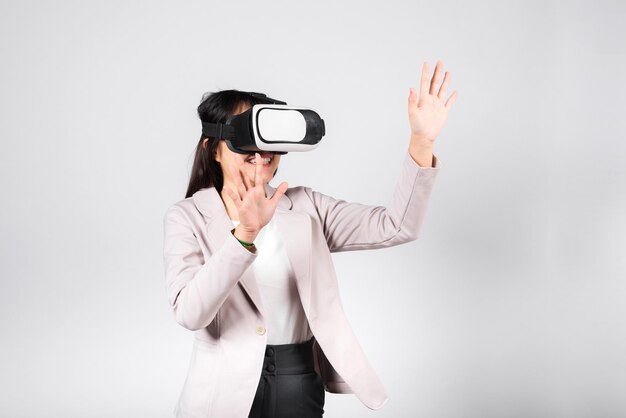 Mulher sorridente animada usa dispositivo de fone de ouvido VR tocando o ar durante a experiência de realidade virtual