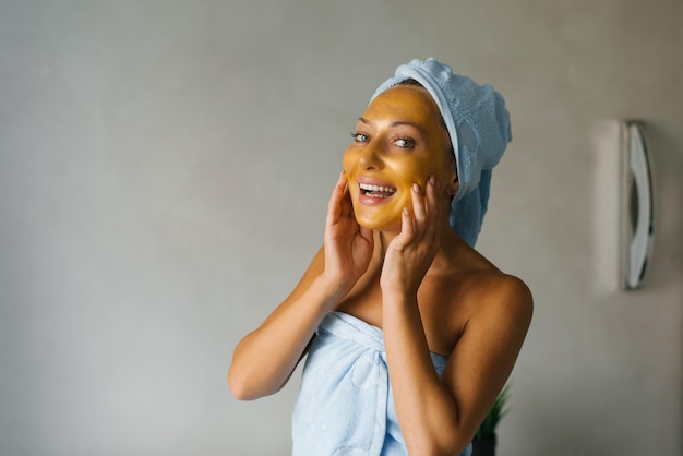 Mulher sorridente aplica uma máscara facial após o banho