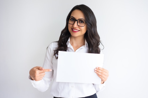 Mulher sorridente apontando para folha de papel em branco