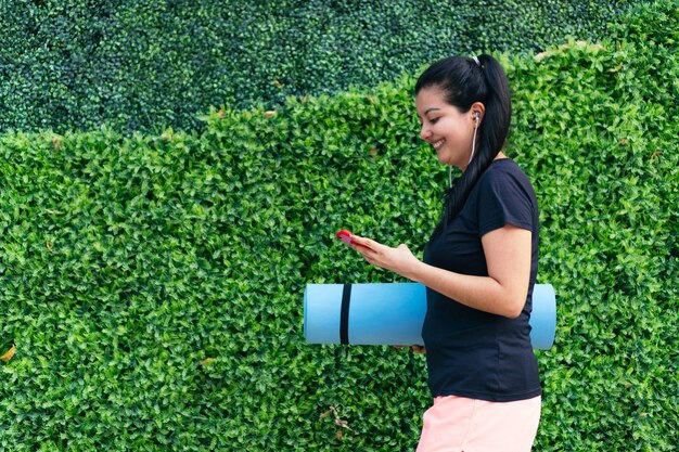 Mulher sorridente caminhando lá fora após a sessão de ginástica