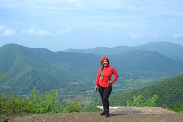 Mulher sorridente com atitude positiva com paisagem de colinas atrás dela