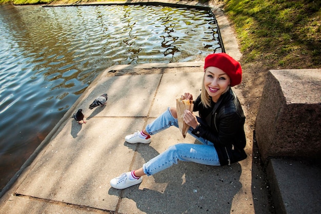 Mulher sorridente com chapéu de boina francesa no parque ao ar livre