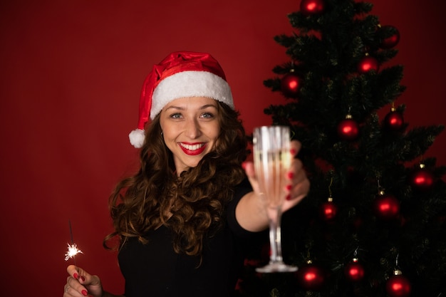 Mulher sorridente com chapéu de Papai Noel celebra o Natal