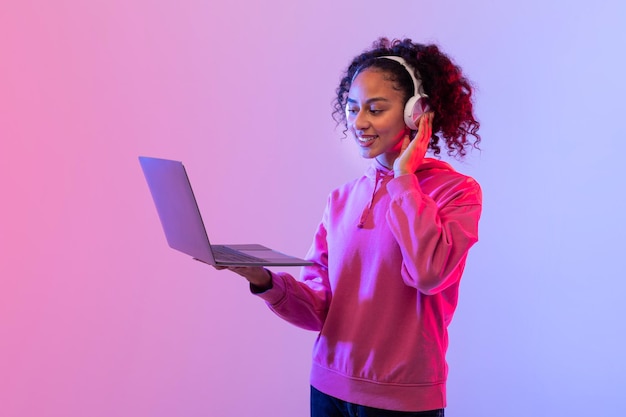 Mulher sorridente com laptop aberto e fones de ouvido