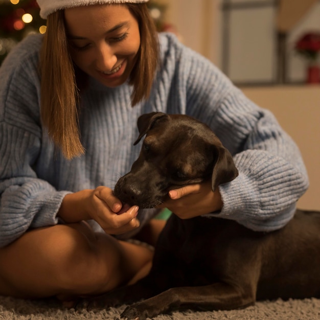 Foto mulher sorridente com seu cachorro no natal