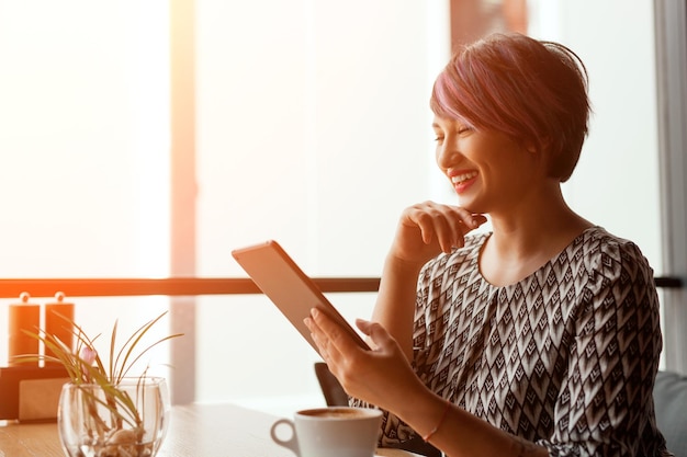 Mulher sorridente com tablet no café