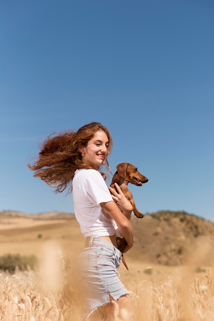 Foto mulher sorridente com tiro médio e cachorro