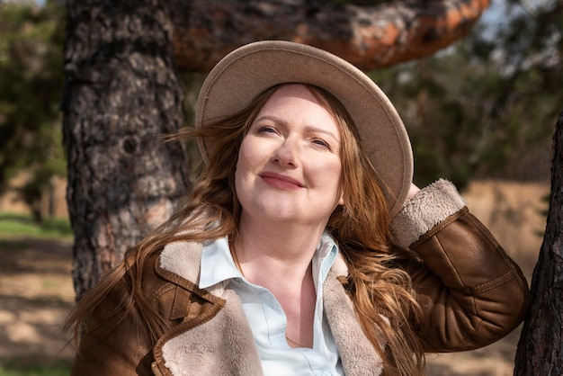 Foto mulher sorridente com tiro médio usando chapéu