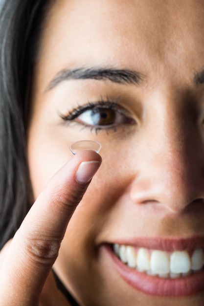 Mulher sorridente com uma lente de contato