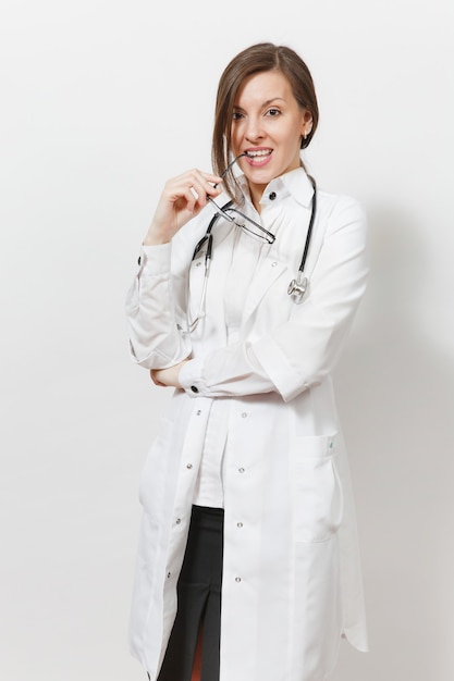 Mulher sorridente confiante experiente sexy jovem bonito médico com estetoscópio, óculos isolados no fundo branco. Médica em vestido de médico. Pessoal de saúde, saúde, conceito de medicina.