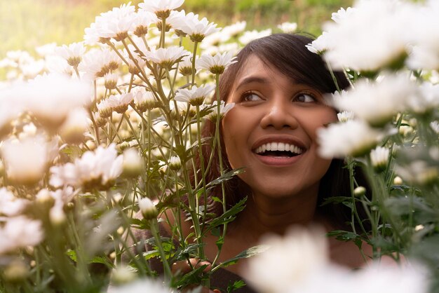 Foto mulher sorridente contra flores florescentes