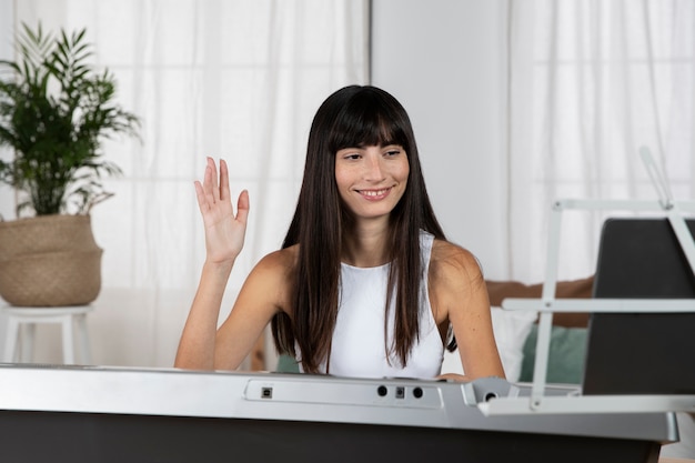 Mulher sorridente de tiro médio com piano