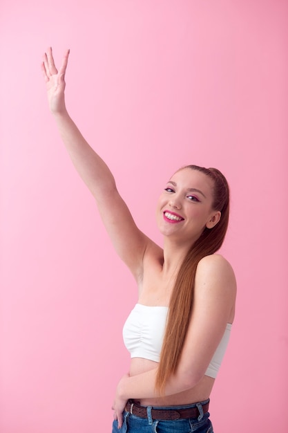 Foto mulher sorridente de tiro médio posando com fundo rosa