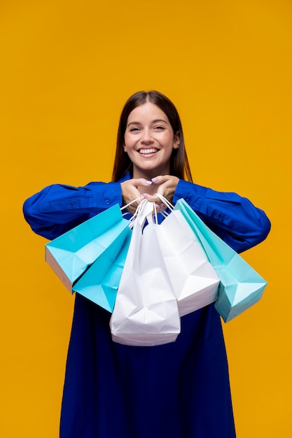 Foto mulher sorridente de tiro médio segurando sacolas