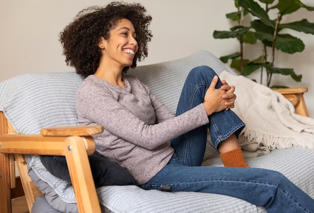 Foto mulher sorridente de tiro médio sentada no sofá