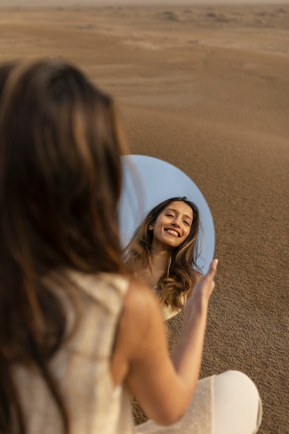 Foto mulher sorridente de vista traseira segurando o espelho