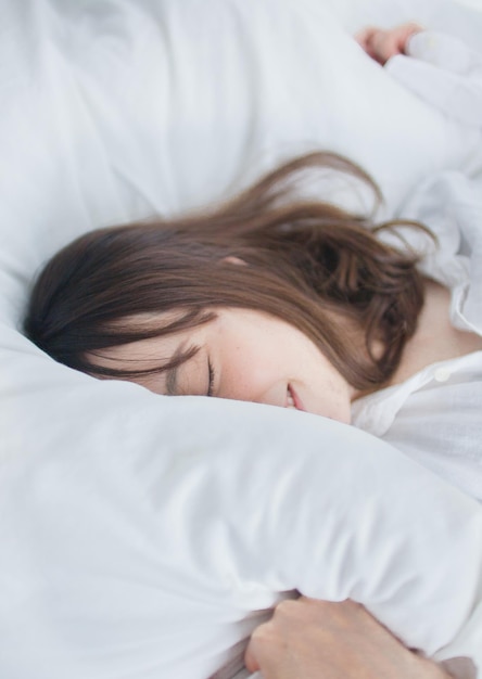 Mulher sorridente deitada na cama